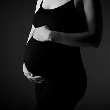 Pregnant client receiving Pilates instruction in a calm studio