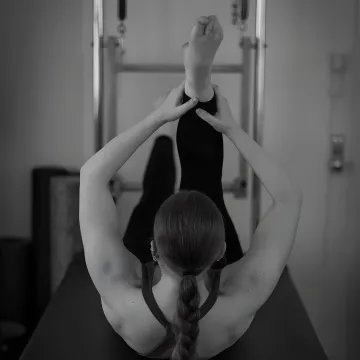 Instructor guiding beginner on Pilates equipment