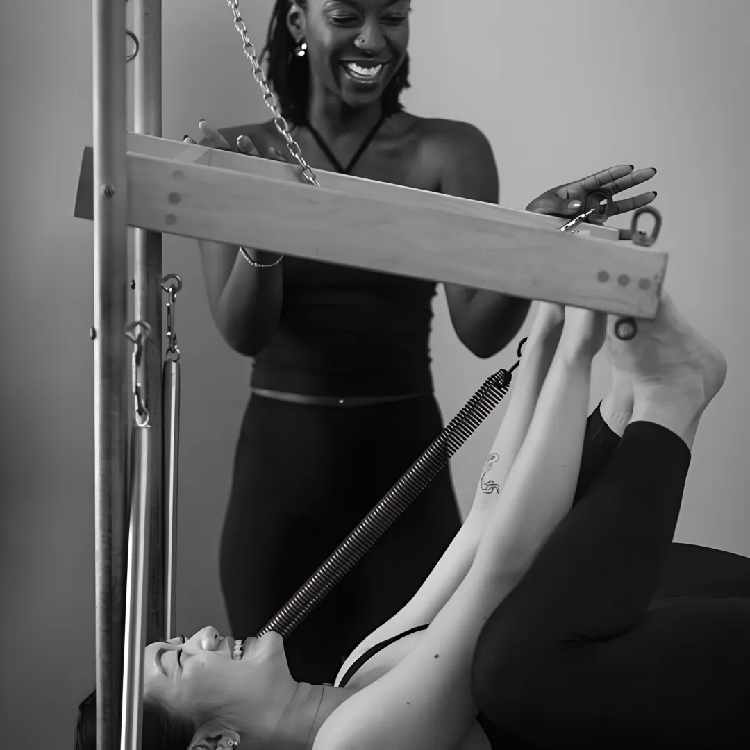 Instructor guiding a client through mat Pilates
