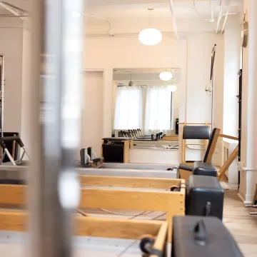Instructor adjusting Pilates equipment for a client