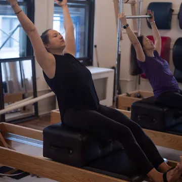 Pilates instructor guiding scoliosis-focused Reformer work