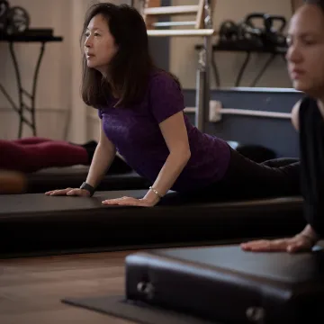 Instructor guiding a mat Pilates class