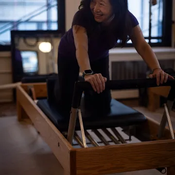 Client practicing Reformer Pilates in a Manhattan studio