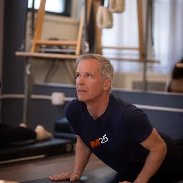 Senior beginner doing Pilates with instructor guidance