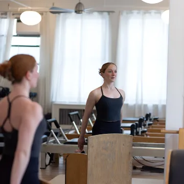 Boutique Pilates studio with instructor guiding a client