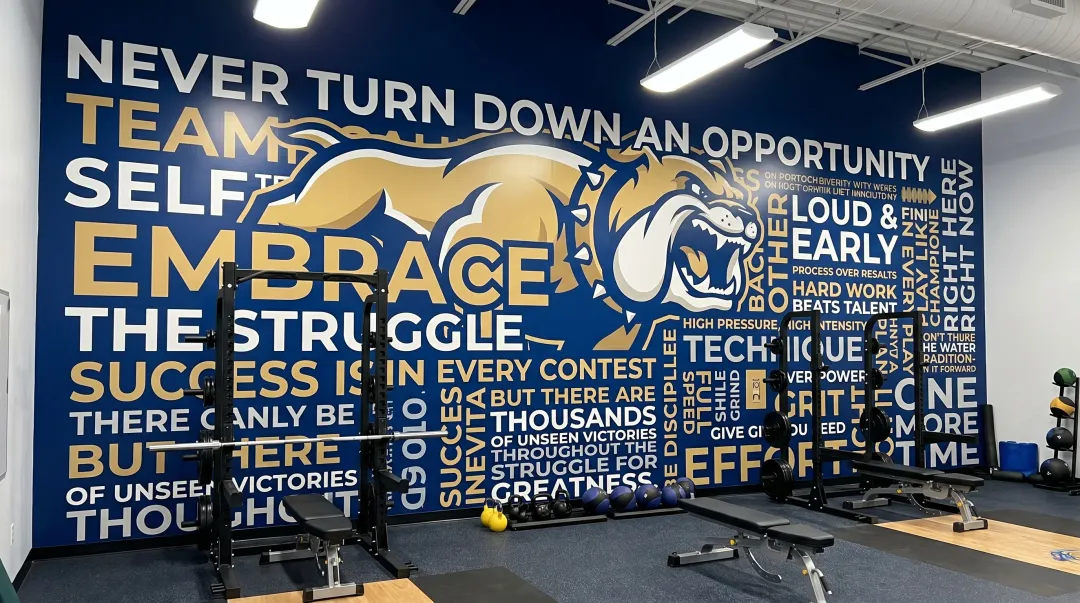 Custom large-format wall mural with team mascot colors and motivational branding in gymnasium