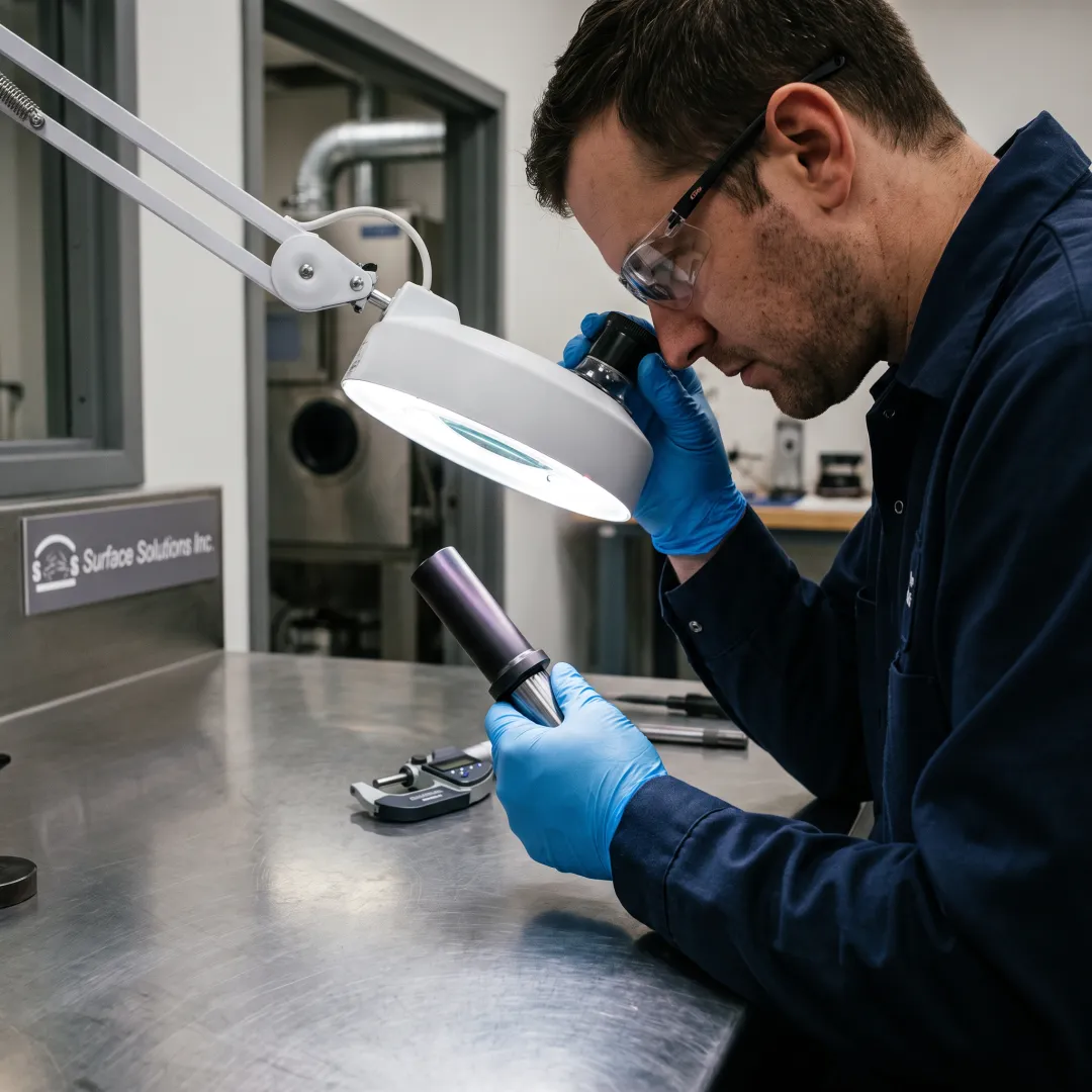 Technician inspecting PVD-coated punch tooling