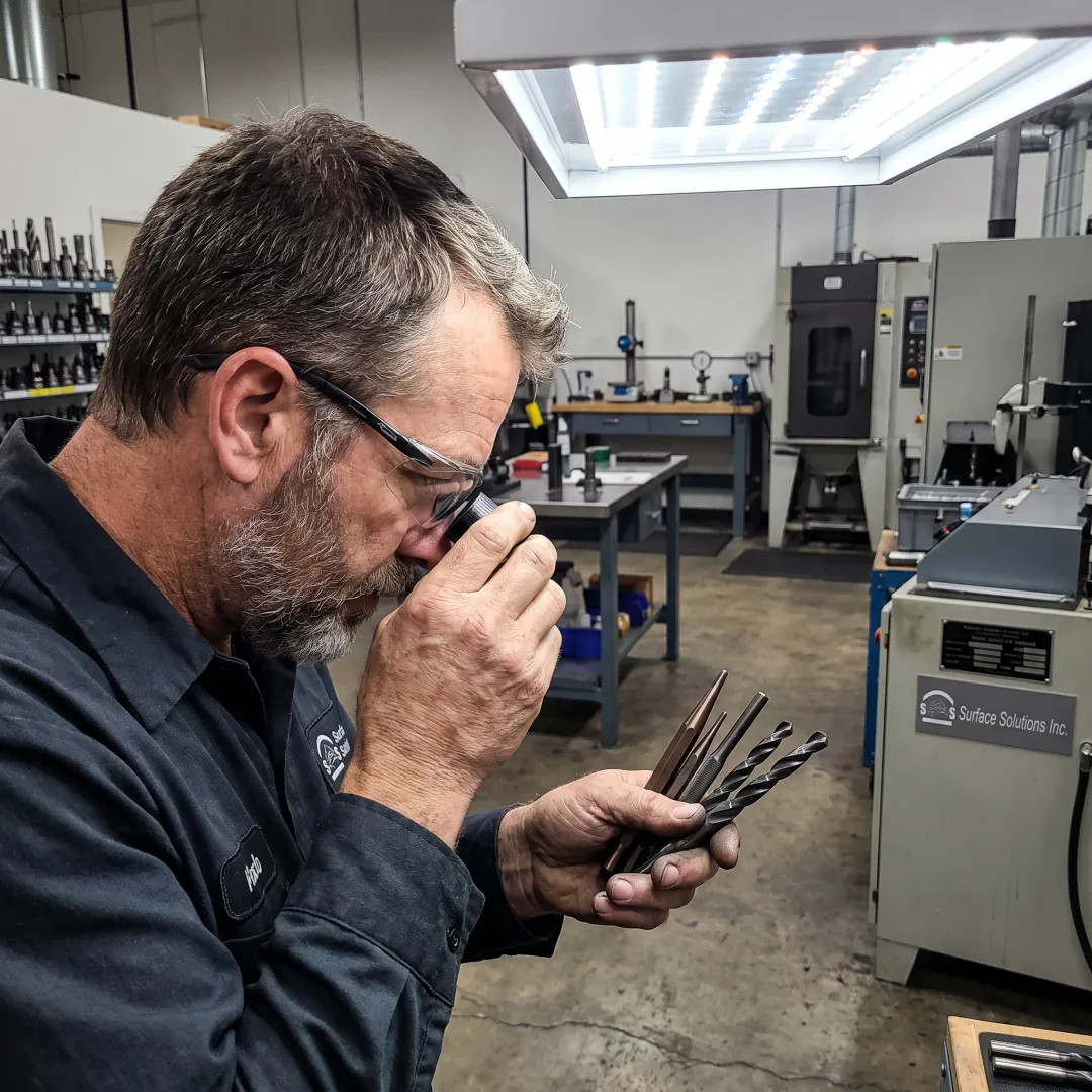 Technician inspecting coated industrial tooling