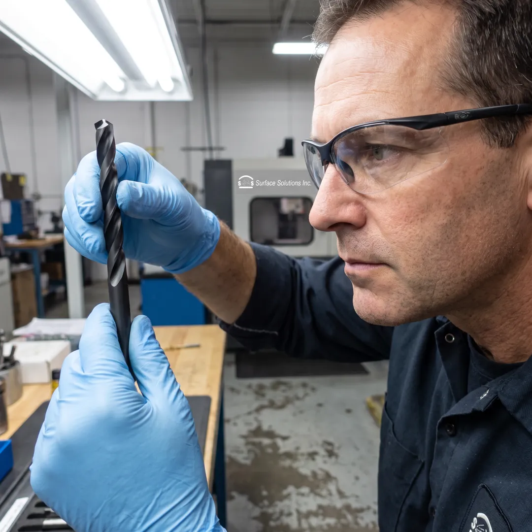 Technician inspecting coated manufacturing tool