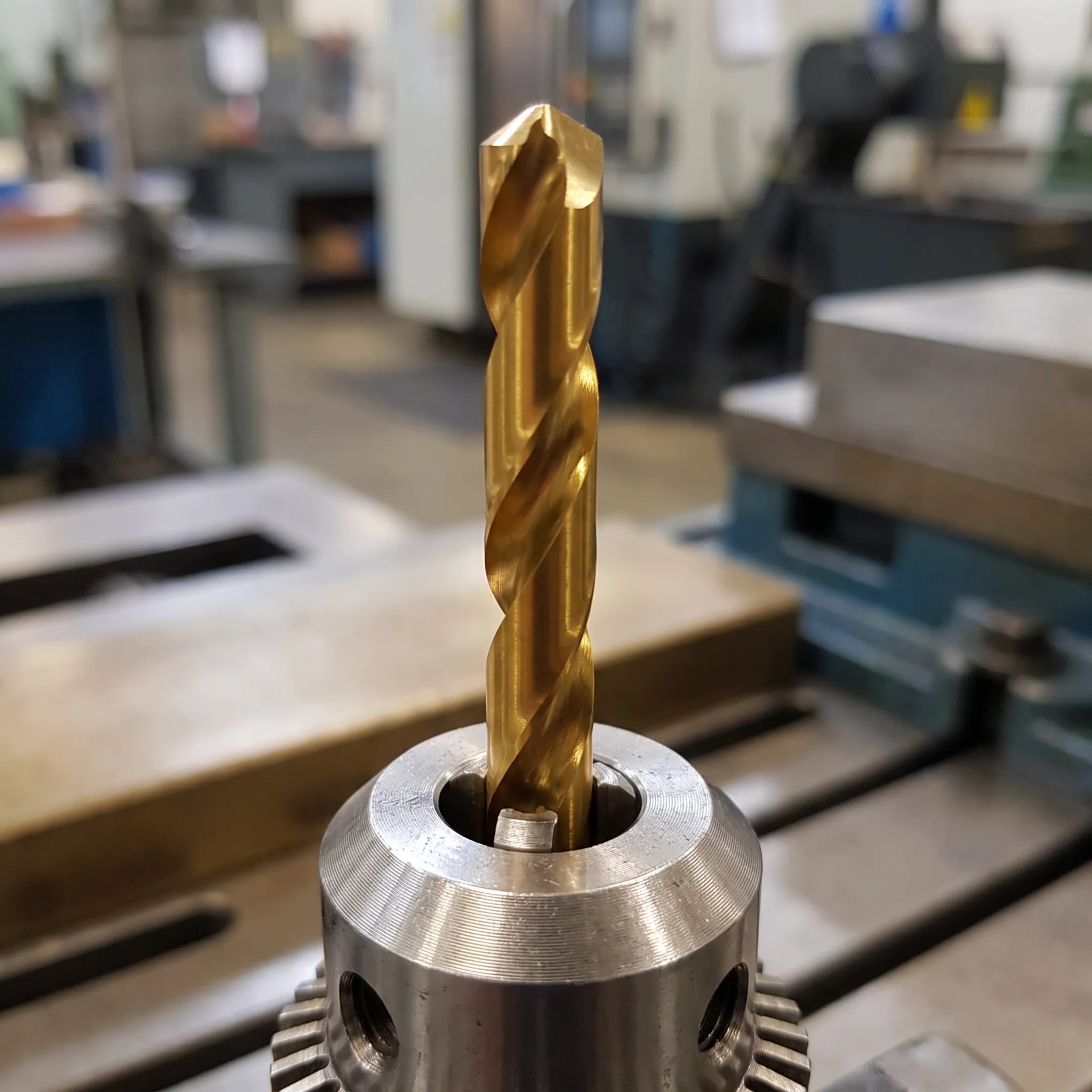 Gold TiN coated drill bit cutting through metal