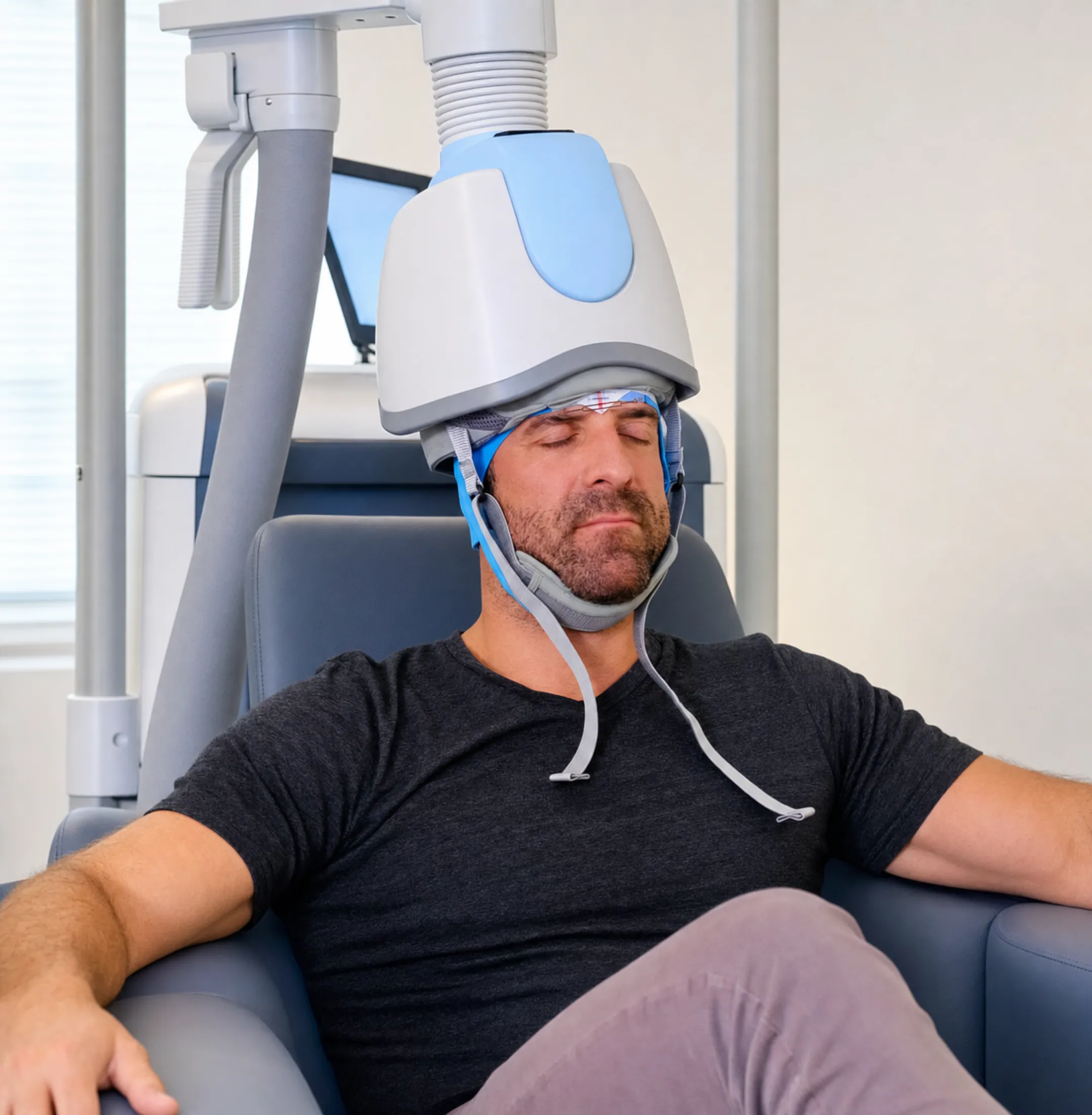 Patient relaxing during Deep TMS therapy session in treatment chair