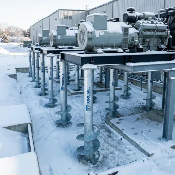 Helical pile foundation system supporting industrial equipment in winter conditions