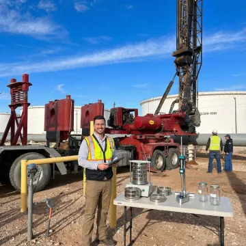 Geotechnical engineer conducting soil testing and site analysis with drilling equipment