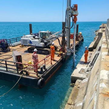 Waterside seawall installation equipment working from marine vessel