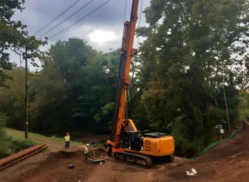 Professional helical pile installation equipment working on deep foundation project
