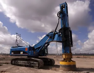 Deep foundation specialists installing helical piles with advanced drilling equipment