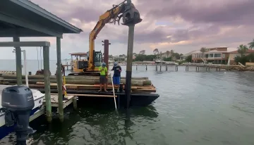Marine foundation construction crew installing helical piles for offshore project