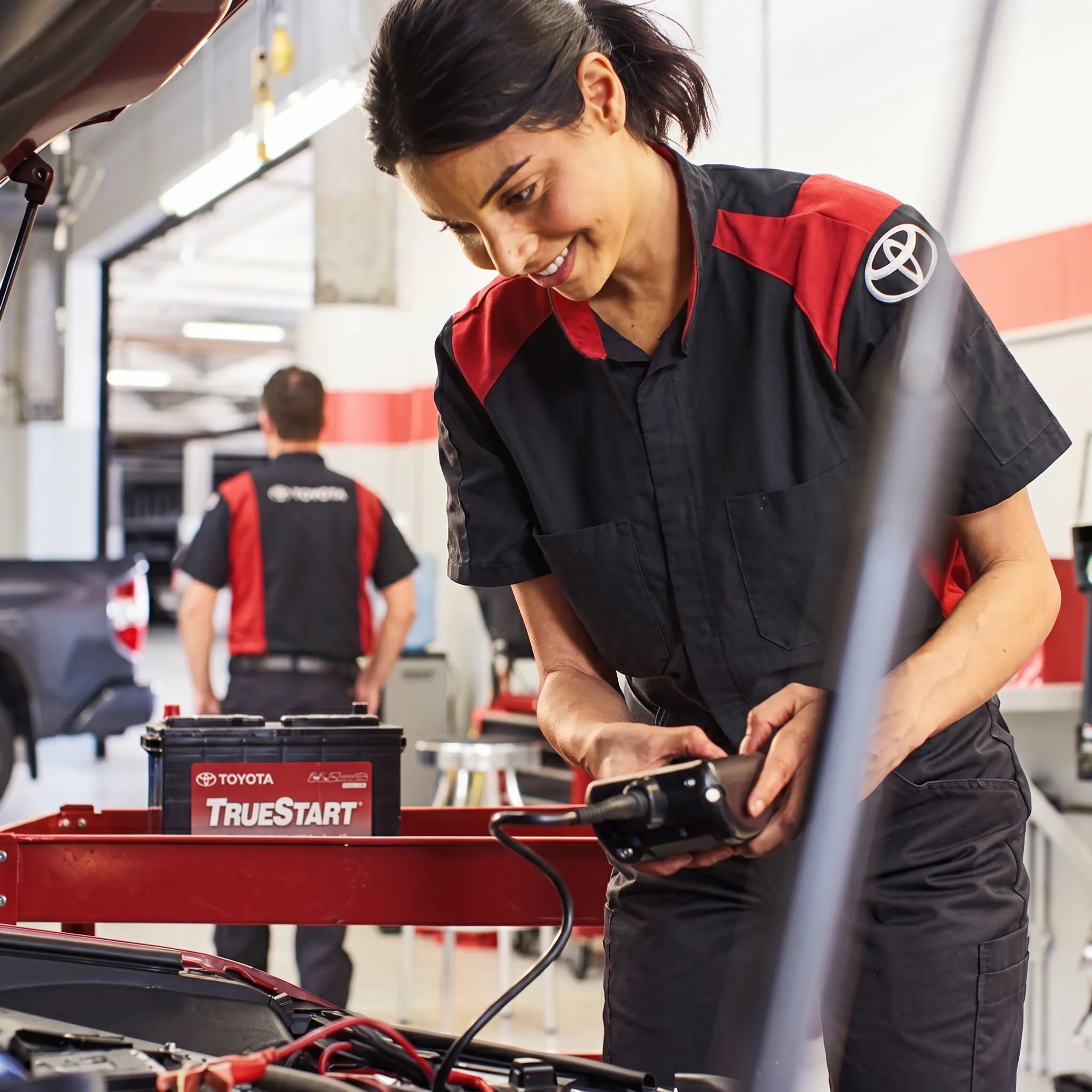 Technician servicing a Toyota Prius hybrid battery and engine components