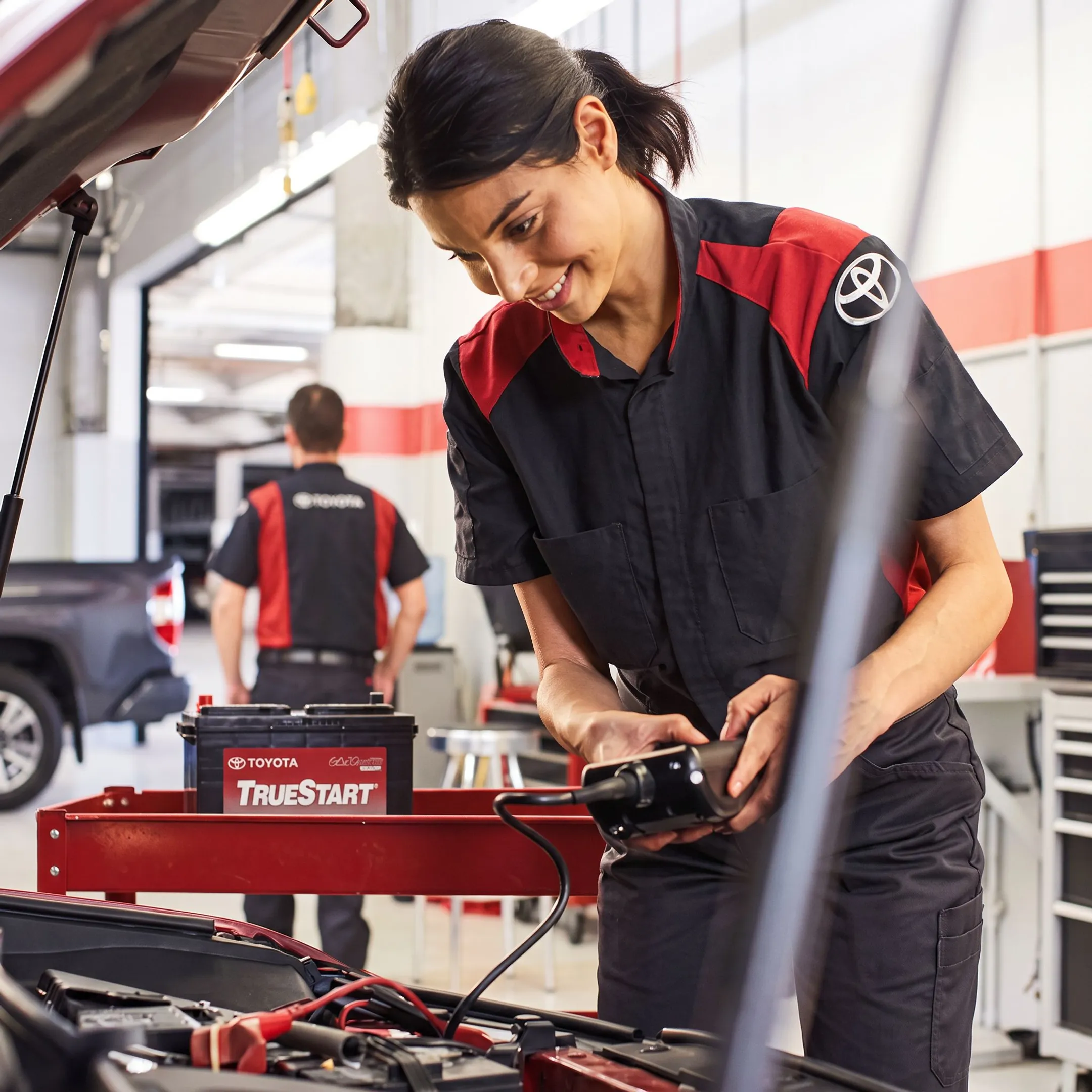 Technician inspecting a Toyota vehicle battery