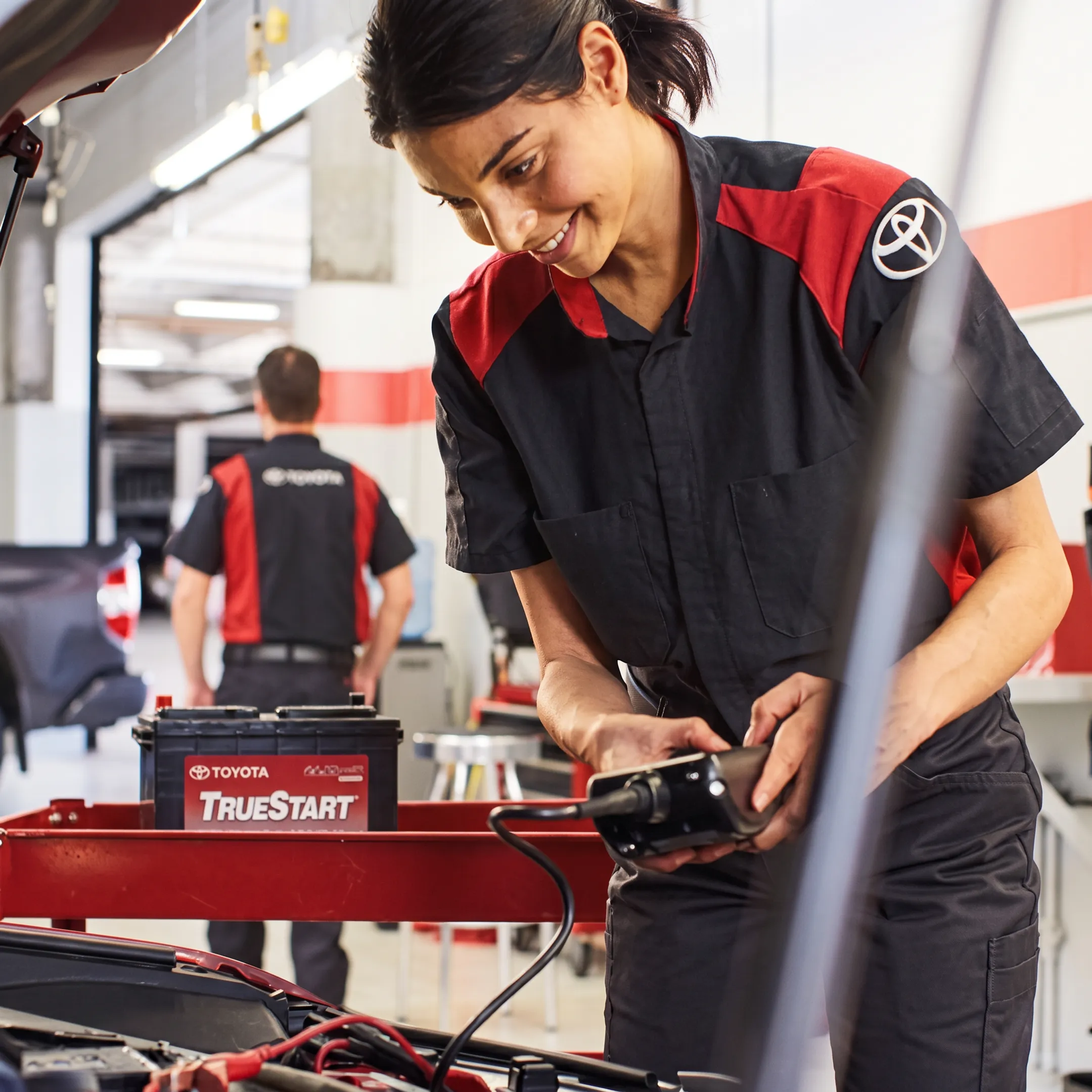 Technician inspecting a hybrid or electric vehicle in a Toyota service bay