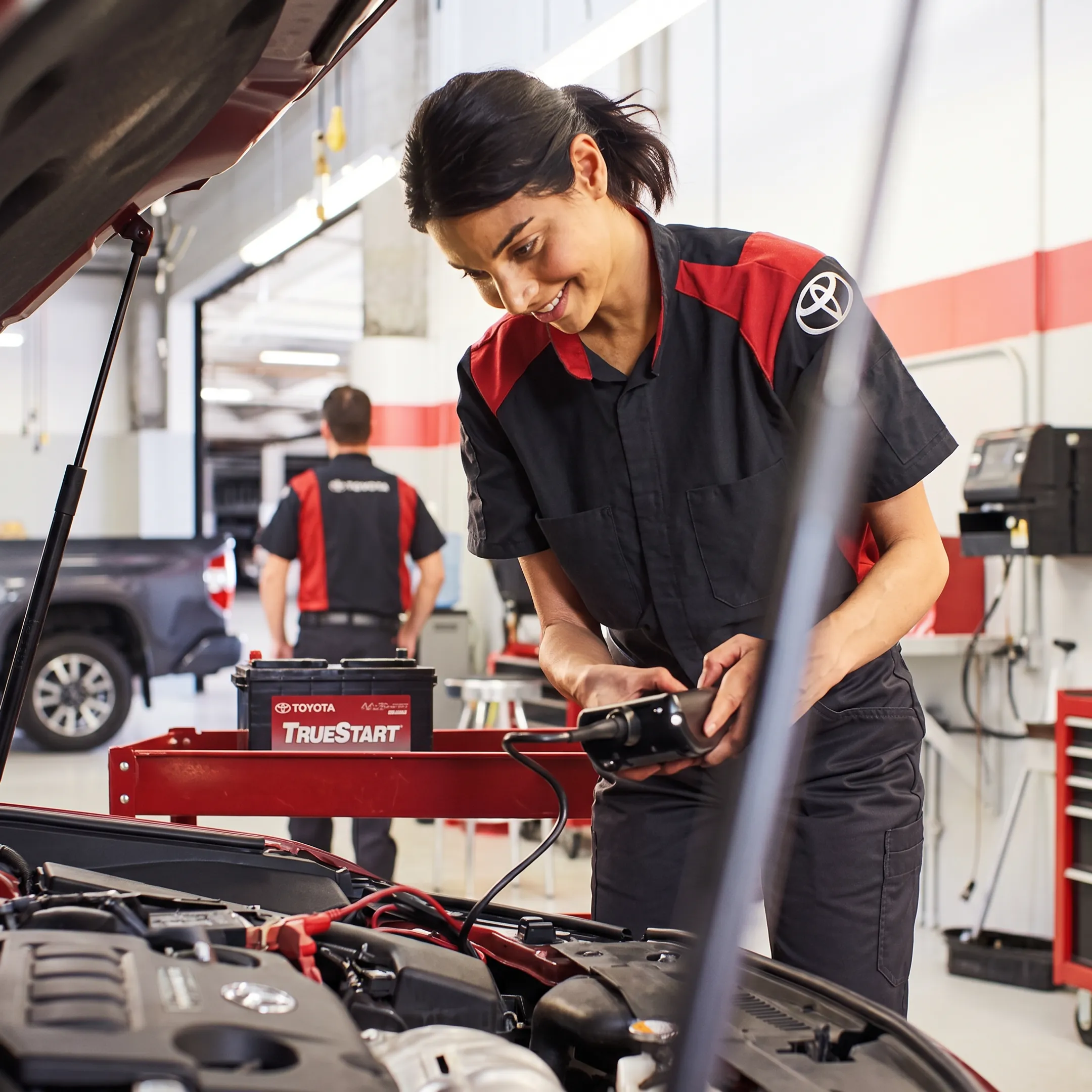 Automotive technician inspecting battery terminals during electrical service