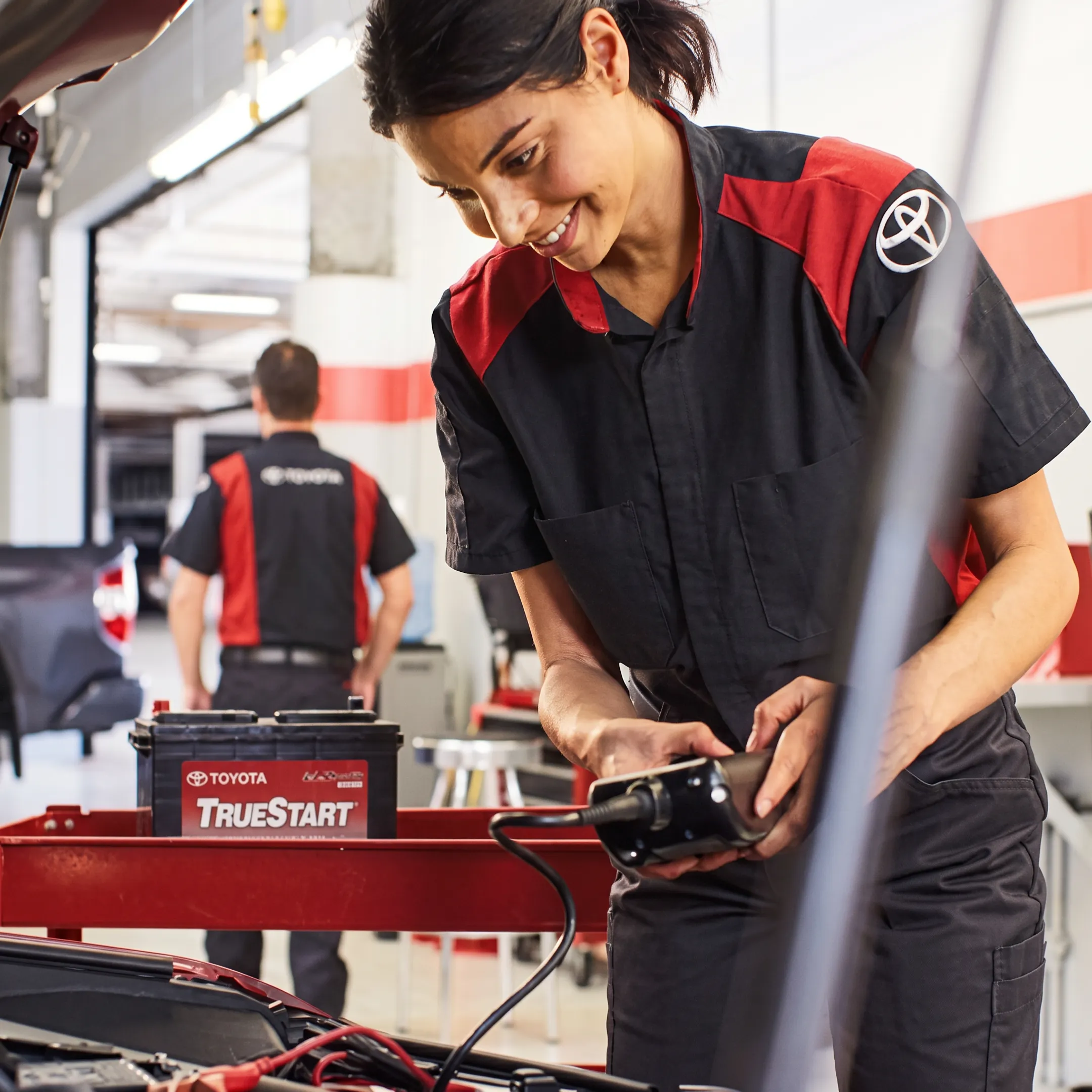Toyota technician diagnosing a hybrid battery system with service equipment