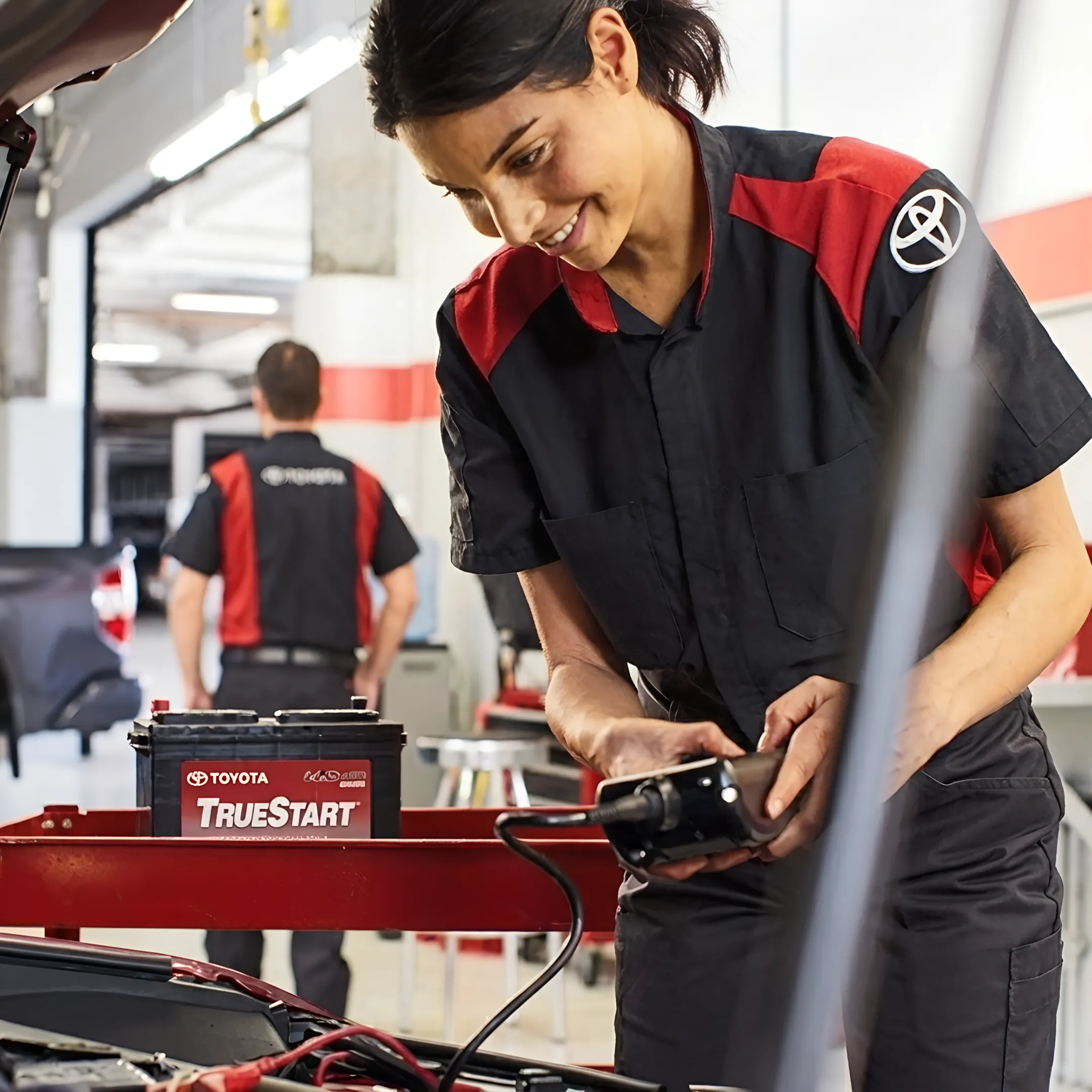 Technician performing hybrid vehicle maintenance at Toyota dealership