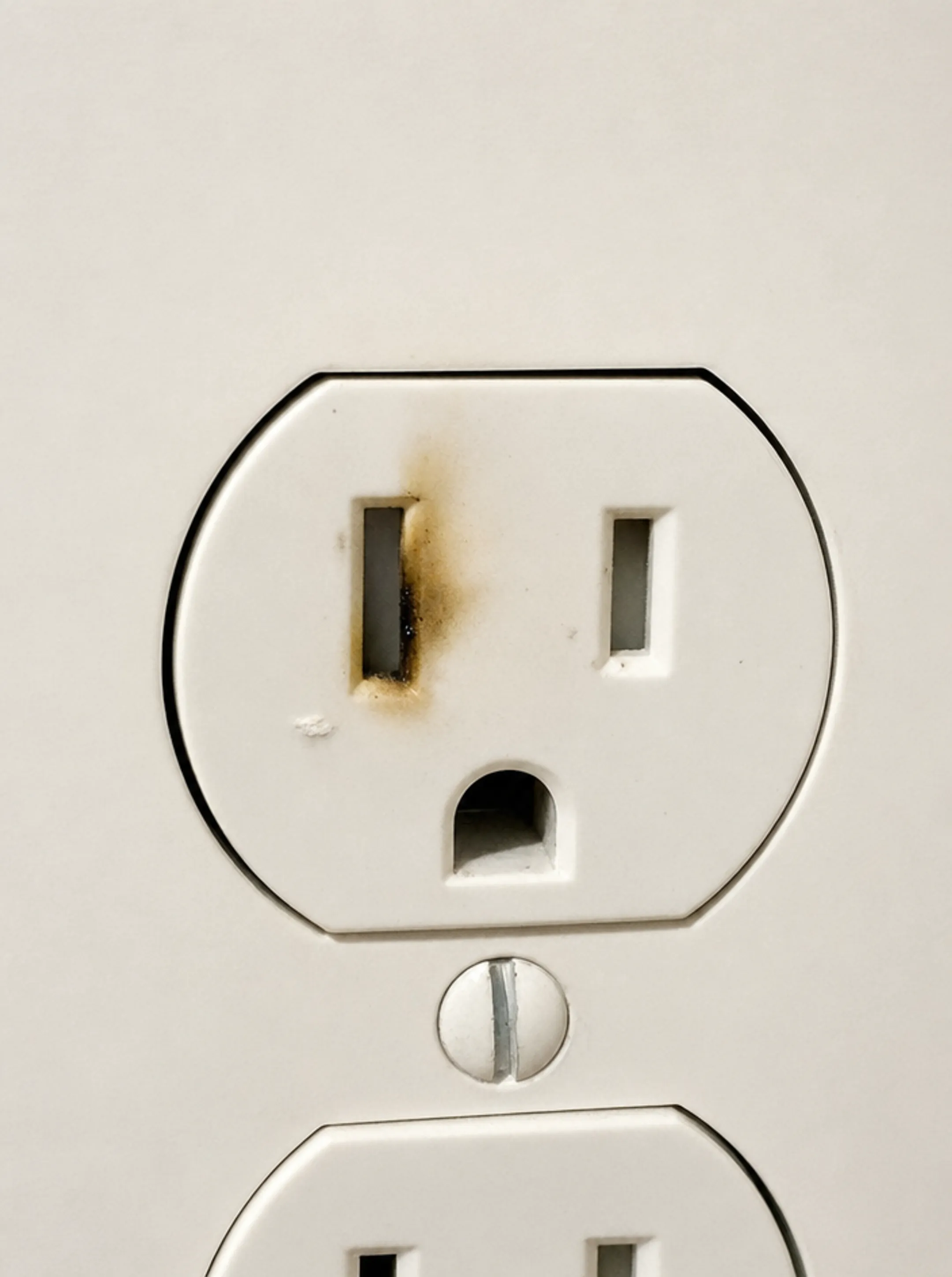 Scorched electrical outlet showing signs of surge damage