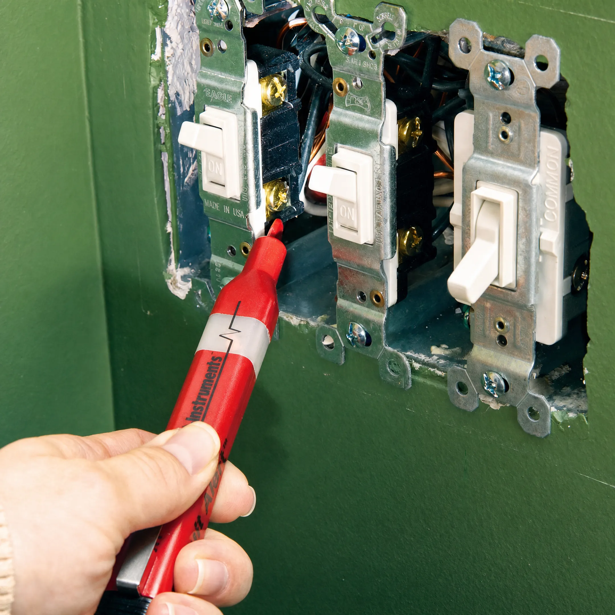 Electrician testing 3-way light switch wiring with voltage tester