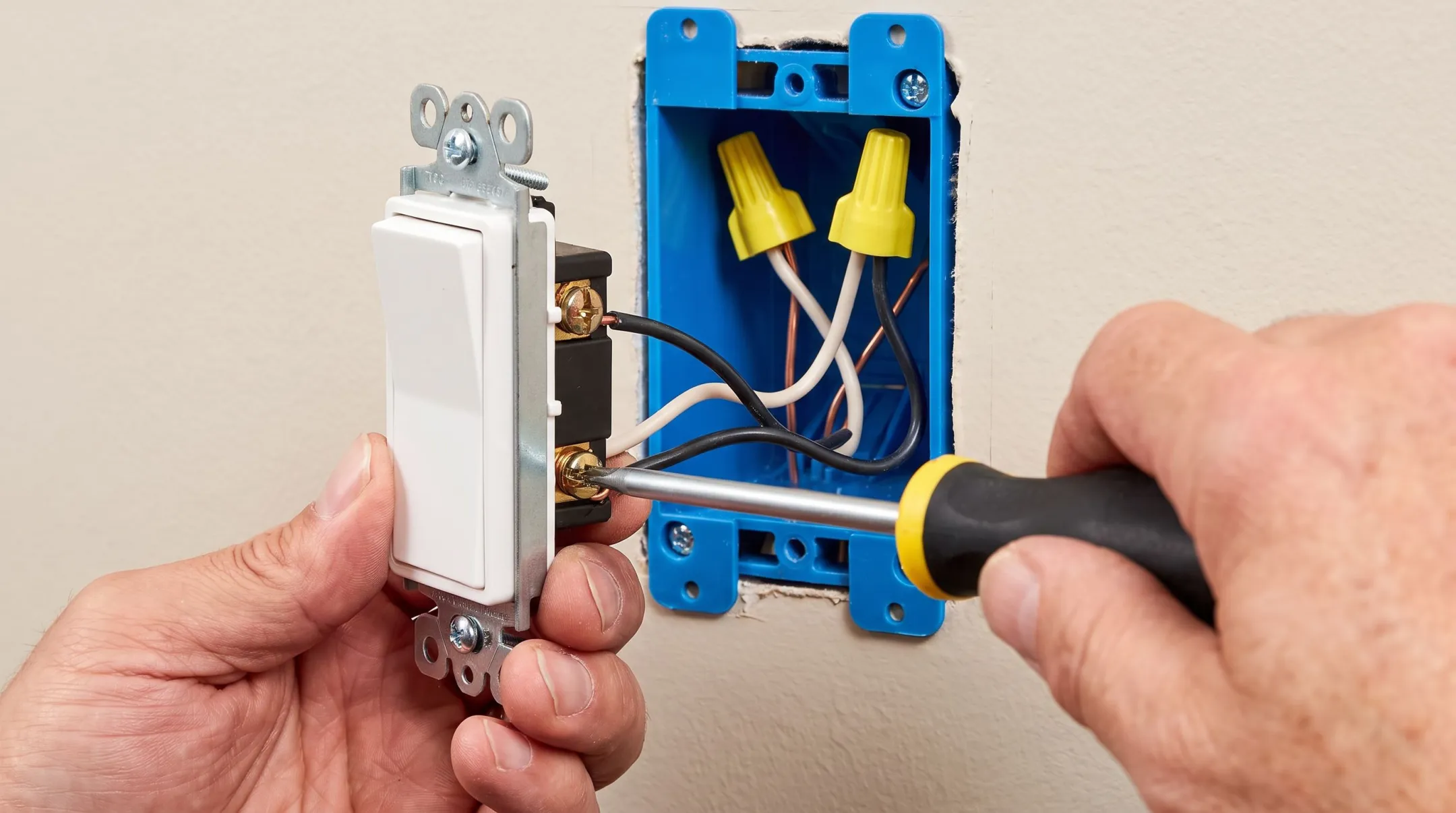 Electrician testing light switch wiring with non-contact voltage tester