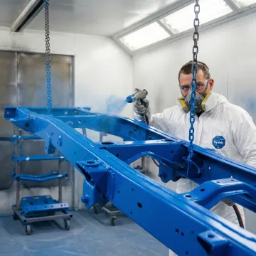Professional 4x4 truck frame being powder coated in bright custom color