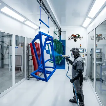 Professional powder coating application on metal fabricated parts in industrial facility