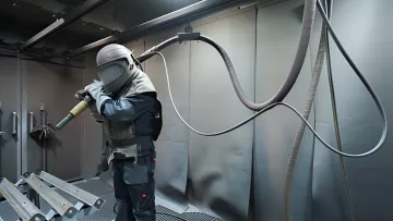 Professional sandblasting technician working on metal surface preparation in Clearwater facility