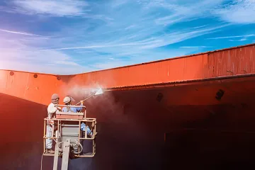 Close-up of wet abrasive blasting creating clean metal surface with water spray