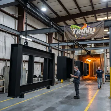 OEM metal parts being powder coated in an industrial finishing facility