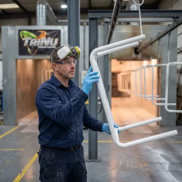 Technician inspecting powder coated medical equipment frame