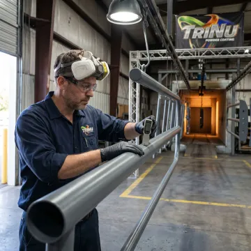 Technician inspecting coated steel parts