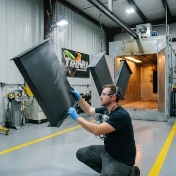 Technician inspecting coated industrial parts