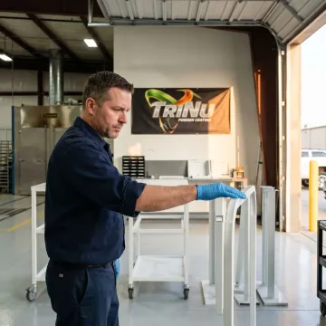Technician inspecting powder-coated OEM medical cart components