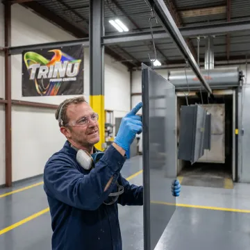 Technician inspecting coated electrical enclosure panels