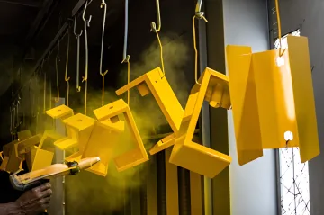 Precision powder coating application on large OEM metal components in industrial facility
