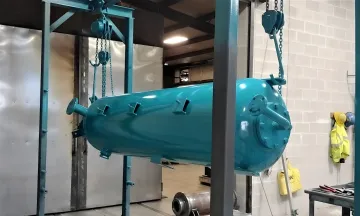 Technician applying marine powder coating to boat parts