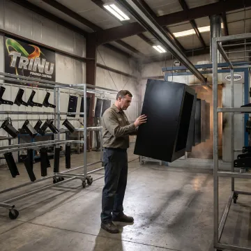 Technician inspecting powder coated OEM metal parts