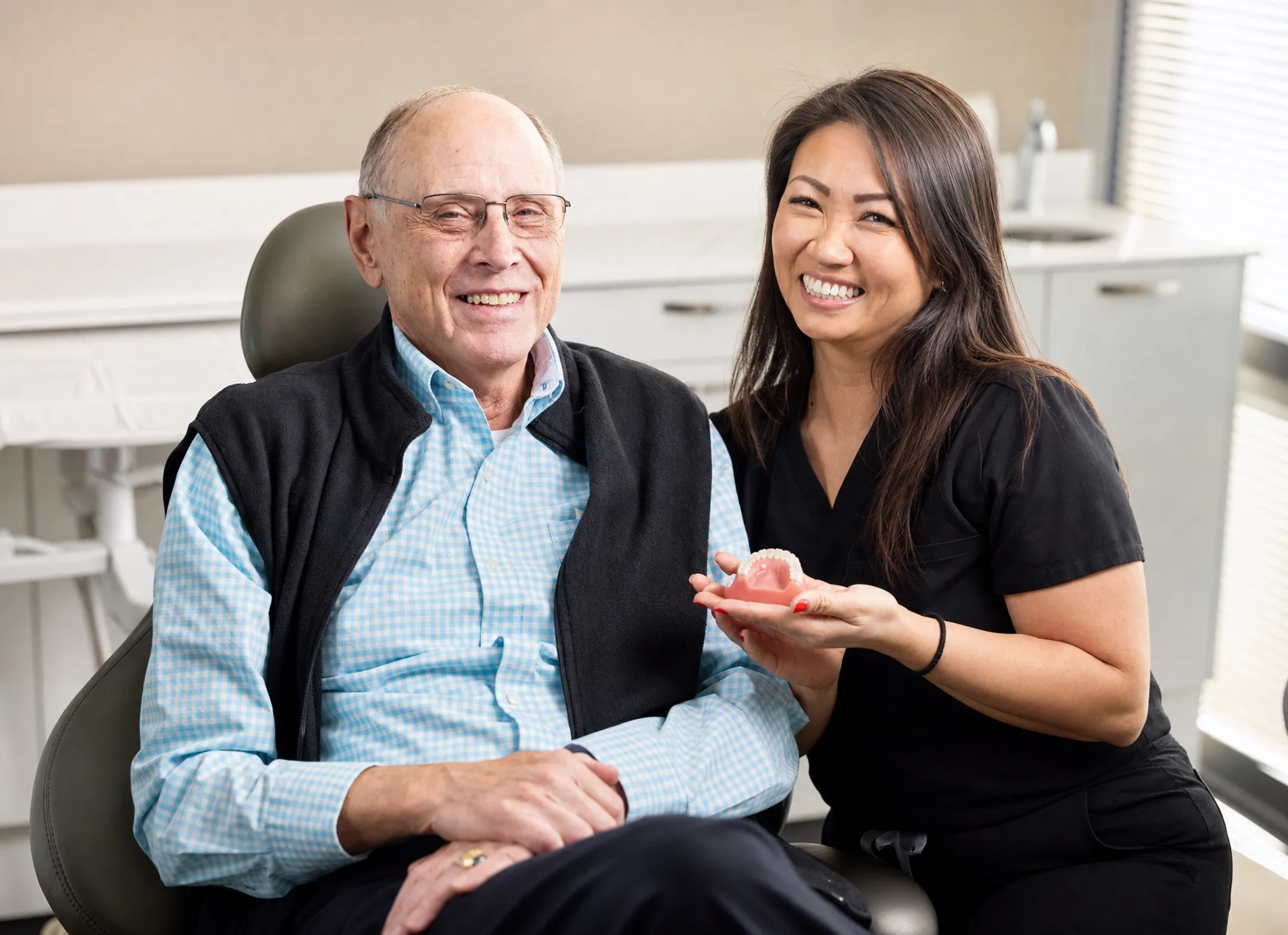 Senior patient consulting dentist about denture and implant treatment options