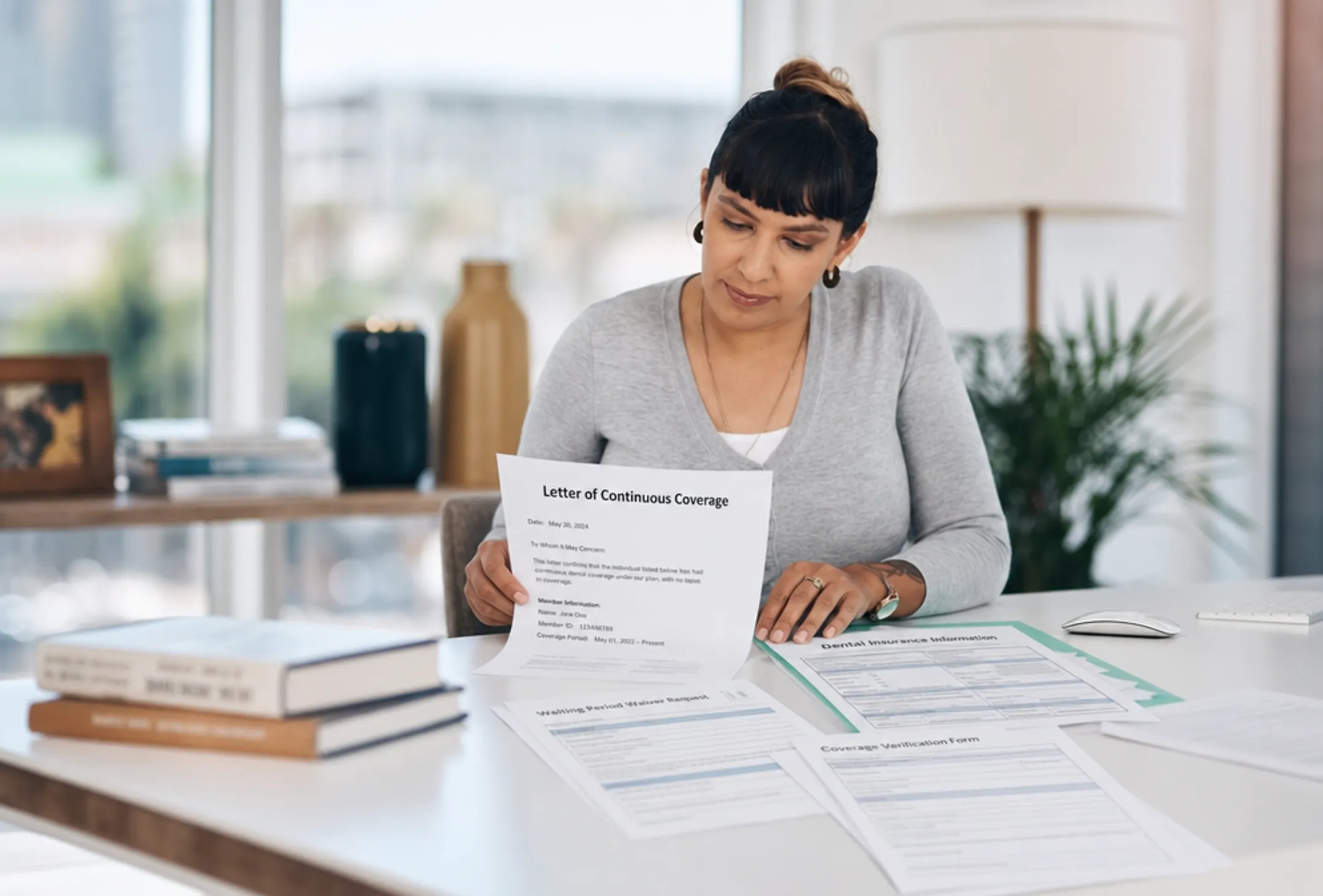 Person reviewing dental insurance policy documents with prior coverage letter