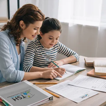 Parent guiding an elementary student through a writing lesson