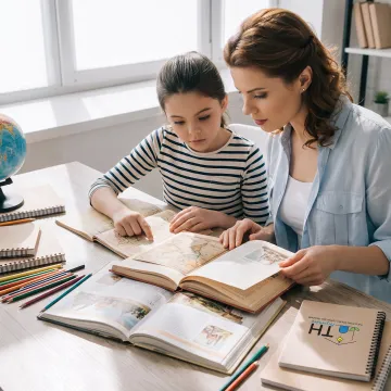Parent and child exploring history books at home