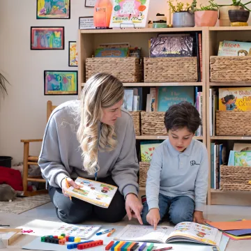 Parent guiding a kindergartener through a hands-on homeschool lesson