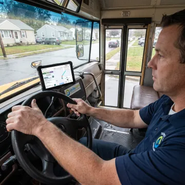 Driver using school bus tablet navigation