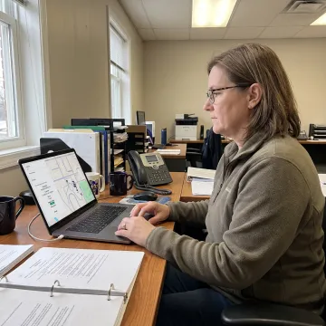 Transportation director reviewing school bus routes on a laptop dashboard